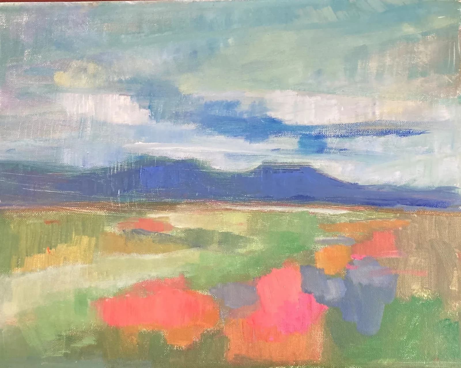 An impressionistic landscape painting in oil and acrylic depicts rolling fields under a cloudy sky with distant blue mountains.